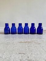 All six cobalt blue bottles lined up front view