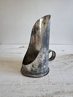 Left front view showing tall curved guard, handle and base