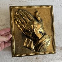 Front view of brass praying hands plaque