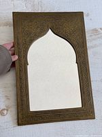 Front view of brass mirror showing full frame and arch opening