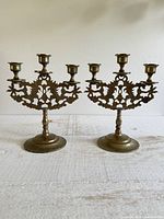 Pair of brass three-arm candelabras front view