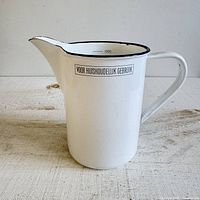 Front view showing Dutch label, handle and spout