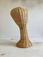Front left view of woven wicker mannequin head showing overall shape