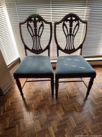 Front view of both chairs showing shield back design and blue seats