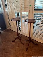 Two matching tall wood plant stands