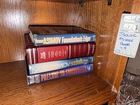 Stack of four Isaac Asimov books on shelf