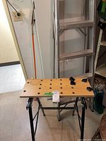 Workbench in front of folded aluminum ladder
