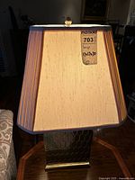 Front view of lit lamp showing shade and base