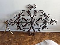 Full view of scrolled metal wall panel and gold rope accent