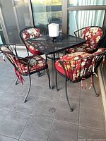 patio set overview with table, four chairs, cushions, candle visible