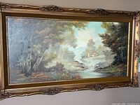 Full view of signed landscape painting within ornate gold frame