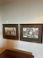 Both framed prints hanging side by side on wall