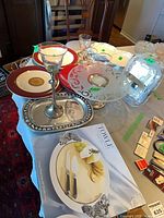 All items laid out including plates, trays, Towle box, picture frame, tall goblet