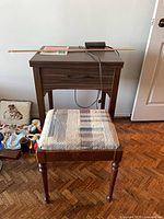 Closed cabinet with stool, foot pedal, manual and ruler visible