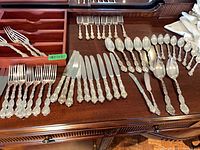 Full set of flatware laid out with wooden divider visible