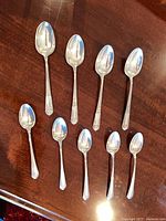 Group shot of nine sterling silver spoons showing two handle patterns