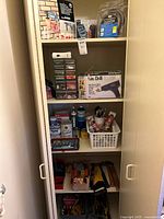 Cupboard showing full assortment of tools, hardware, paint and supplies