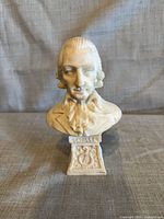 Front view of alabaster bust showing facial detail, base inscription SCHILLER