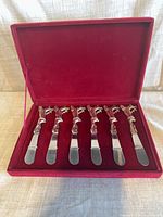 Open presentation box showing six spreaders in place