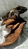 Front view of brown bat puppet showing wings spread and head profile