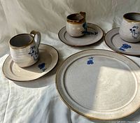Tea set showing three cups on saucers and larger plate