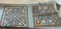 Folded and unfolded fabric pieces showing two different Celtic knot panel designs