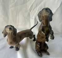 Front view of both porcelain dachshund figurines