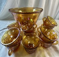 Punch bowl with several cups arranged to show exterior pattern and iridescence