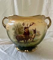 Front view showing stag and doe scene, handles, footed base
