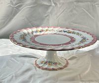 Side view of pedestal cake plate showing height and floral pattern