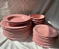 Stacked pink Fiesta plates and bowls showing quantities