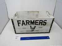 overall view of wooden crate front with FARMERS graphic