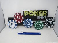 Full view of metal sign with five poker chip discs and ruler for scale