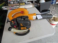 Left side view showing full blower body, handle, nozzle, fuel tank