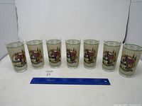 All seven glasses in a row with ruler for scale