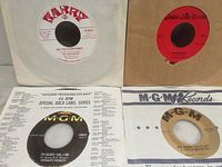 Four records in sleeves showing labels and sleeves