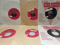 Five 45 RPM records in sleeves