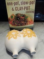 Clay baker front with cookbook behind