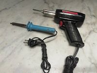 Both soldering tools side by side, cords visible