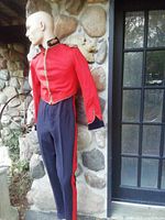 Full view of mannequin wearing red jacket and navy trousers