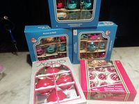 Five ornament boxes grouped on surface showing packaging fronts