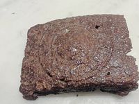 Front view of corroded WWI German belt buckle showing raised circular emblem