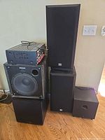 Overall view of stacked audio equipment showing Denon receiver, three subwoofers and pair of Cerwin-Vega speakers