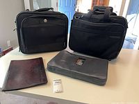 Front view of two rolling bags, leather padfolio and eBags cube