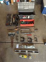Full layout showing toolbox, trays, clamps, crowbars, levels, saw, caulk gun and other tools