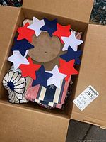 Box containing felt star wreath atop assorted patriotic items