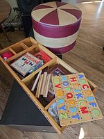 Overall lot with foot cushion and wooden tray containing games and puzzle
