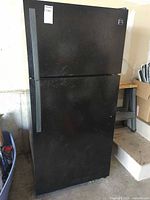 Front view of Kenmore black top-freezer refrigerator showing full height and handles