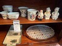 Overall lot on shelves showing Lenox bowls, vase, mug, Santa shaker, snowman shakers, Spode divided tray and oval tree platter