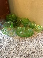 Group shot of all green Depression glass pieces arranged on carpet